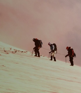 People walking up a sand dune