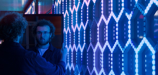 Two guys looking at each other near the blue screen