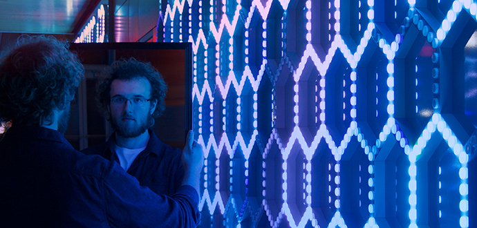 Two guys looking at each other near the blue screen