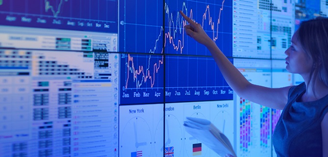 Woman tracing a graph line on a big screen